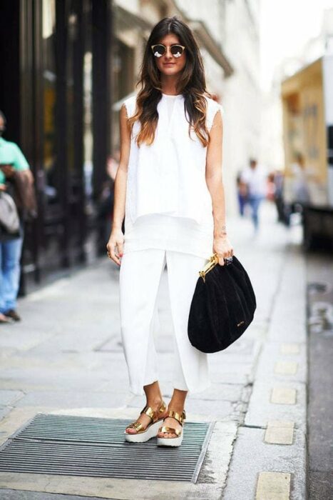 Chica usando un look total white con sandalias de color dorado 