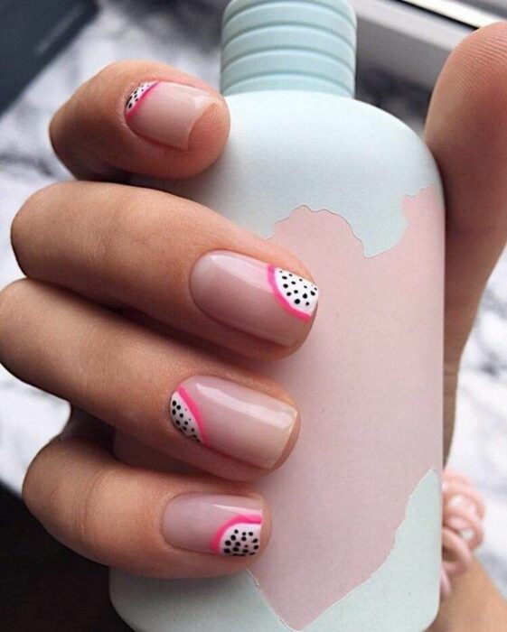 Manicura en tono rosa pastel de fondo con decorado de fruta del dragón; Manicuras frutales para darle sabor a tu primavera