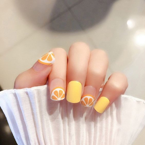 Manicura en color amarillo con rodajas de naranjas; Manicuras frutales para darle sabor a tu primavera