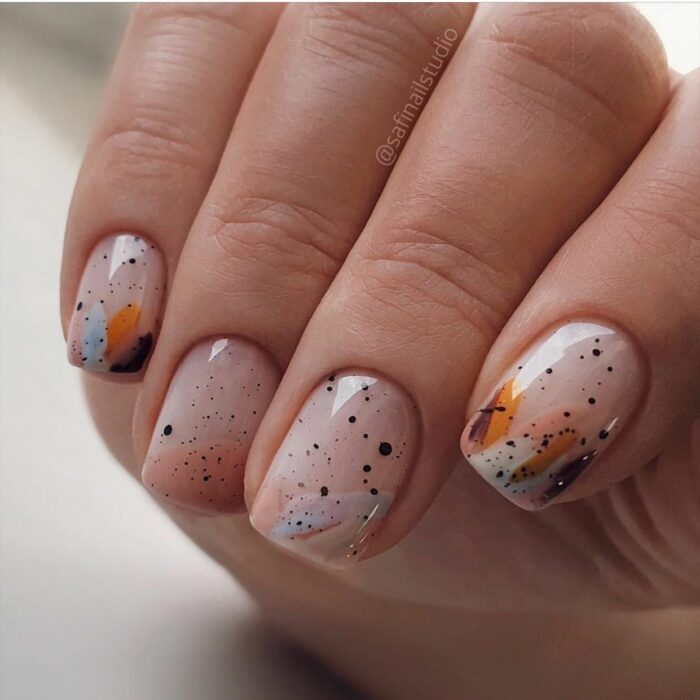 Chica con las uñas pintadas en tonos nude con colores 