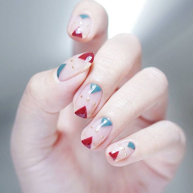 Chica con las uñas pintadas en tonos nude y una mezcla de tonos rojo con azul 