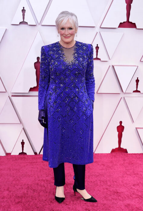 Glenn Close usando un vestido de color azul con un pantalón de color negro 