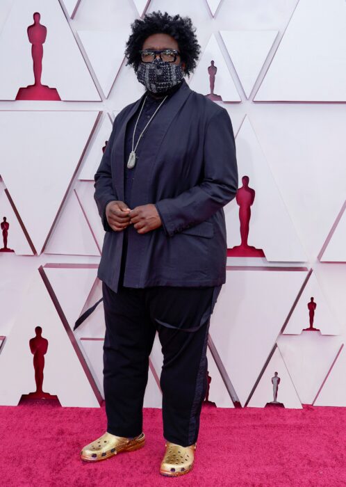 Questlove usando un atuendo de color negro con crocs doradas en la entrega de premios oscar 2021