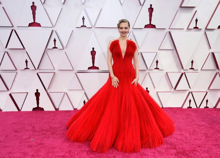 Amanda Seyfried en la alfombra roja de los oscar usando un vestido de color rojo con escote palabra de honor 