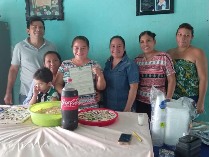 Mujer sosteniendo su acta de divorcio junto a su familia y festejando