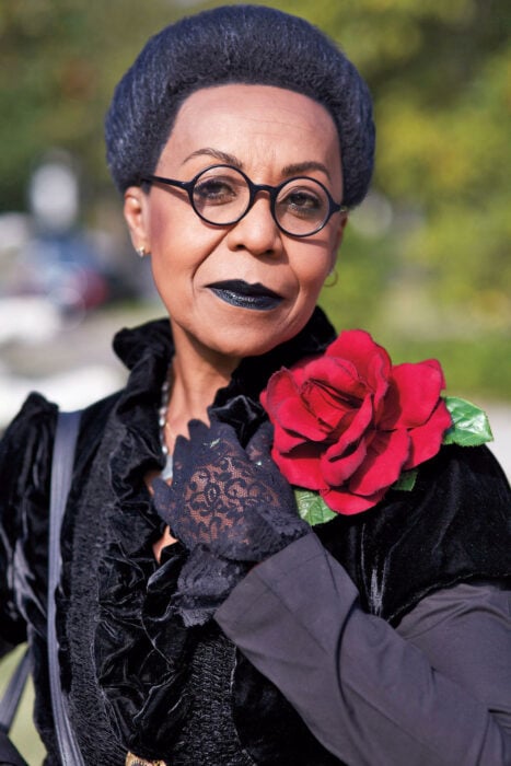 Mujer de la tercera edad vestida de color negro con una rosa adornando su atuendo