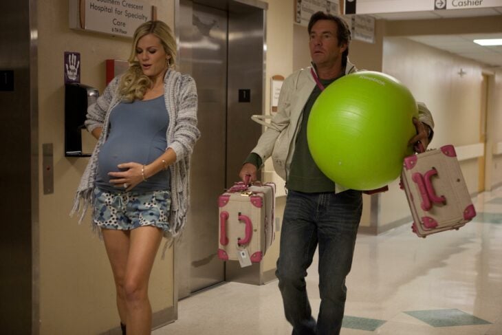 Mujer caminando embarazada dentro del hospital 