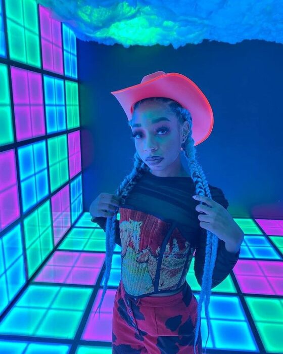 Chica usando un sombrero vaquero con líneas neón 