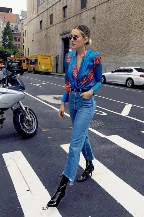 Chica usando una blusa de satín de color azul con flores de color rojo