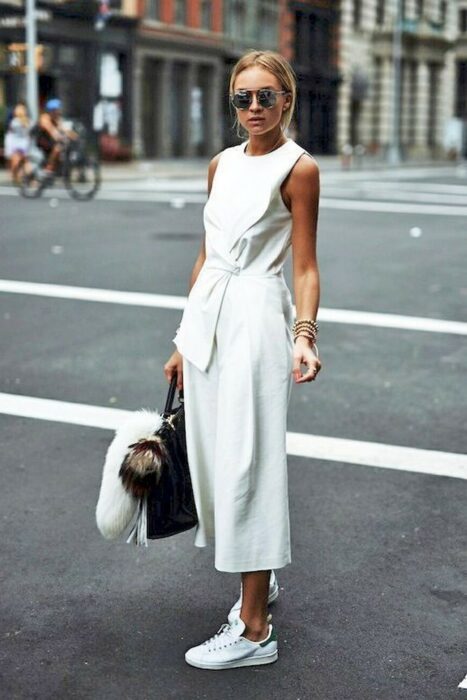 Chica usando un jumpsuit de color blanco con tenis blancos 