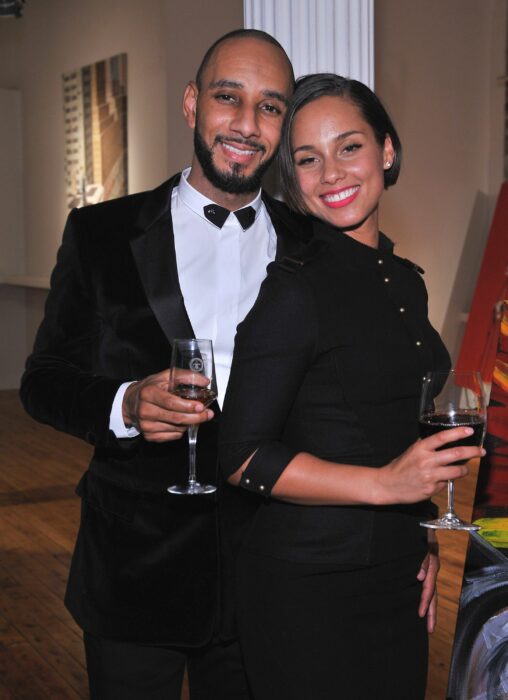 Alicia Keys y Swizz Beatz posando juntos mientras toman una copa