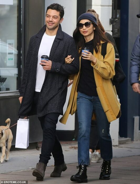 Gemma Chan y Dominic Cooper dando un paseo mientras están tomados del brazo