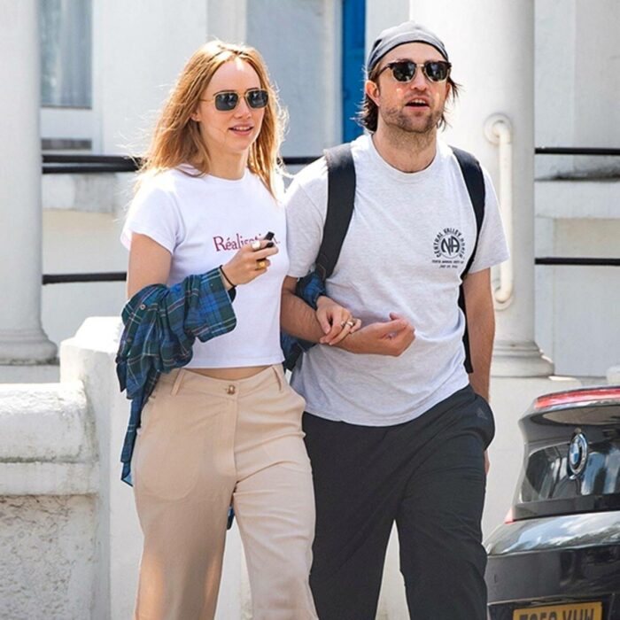 Suki Waterhouse y Robert Pattinson caminando juntos y tomados de los brazos