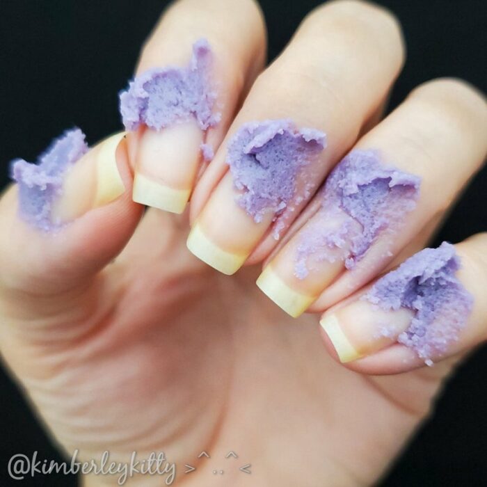 Uñas con crema exfoliante de color morado 