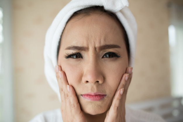 Chica mirando su rostro después de salir de la ducha 