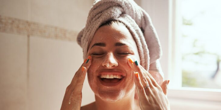 Chica mirando su rostro después de salir de la ducha 