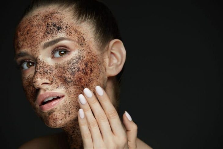 Chica exfoliando su cara  