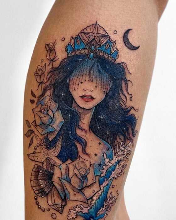 Tatuaje de mujer levando una corona azul; Tatuaje de Robson Carvalho
