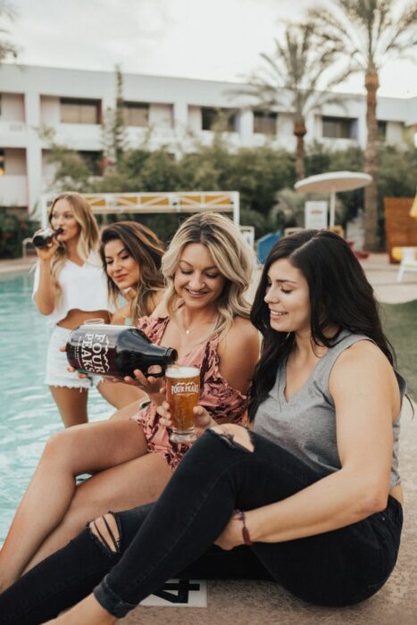 Chicas junto a una alberca bebiendo cerveza; Tomar cerveza podría disminuir el riesgo de Alzheimer estudio 