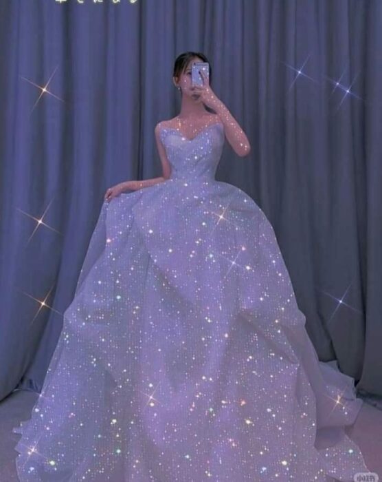 Chica usando un vestido de princesa con brillos y escote palabra de honor