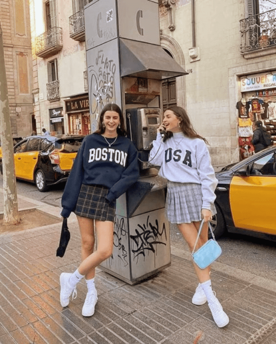 chica de cabello castaño largo, sudadera azul marino, sudadera gris holgada, minifalda gris, minifalda azul de cuadros, tenis blancos de botín