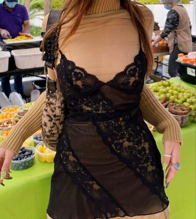 chica de cabello castaño usando un vestido de encaje café con negro, tipo camisón, con top beige de manga larga y cuello alto