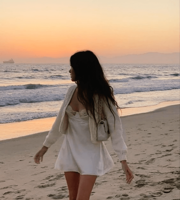 chica de cabello oscuro largo con vestido blanco de satén tipo camisón con cárdigan blanco