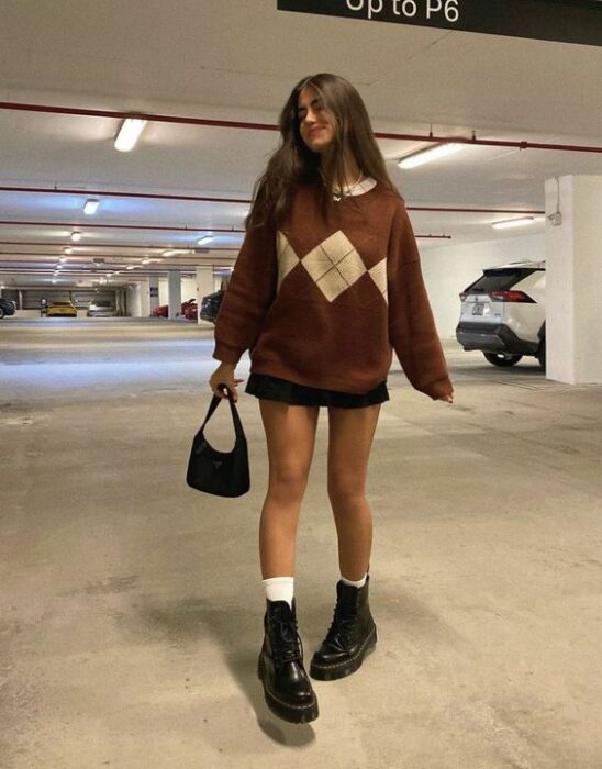 chica llevando outfit estilo colegial con sueter amplio y botas militar;13 Outfits colegiales por sí extrañas tus días de escuela