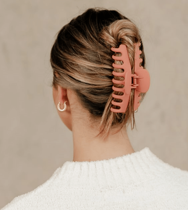 chica rubia con top blanco, pinza para el cabello rosa larga