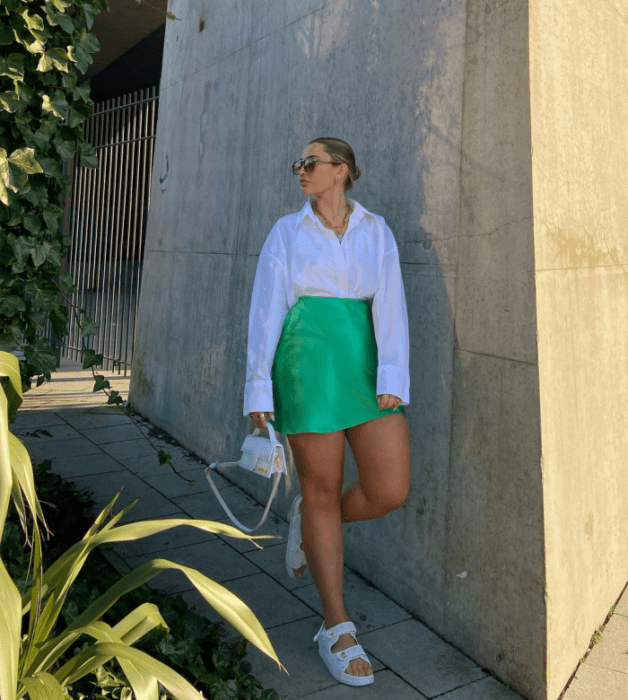 chica con falda beige y top blanco de vestir, cabello claro