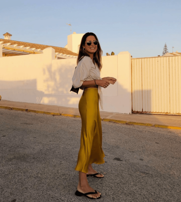 chica con falda beige y top blanco de vestir, cabello claro