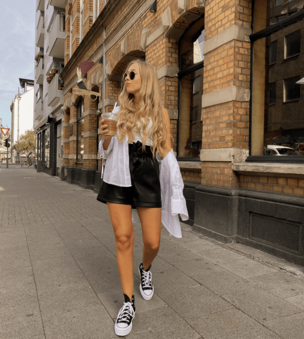 chica con falda beige y top blanco de vestir, cabello claro