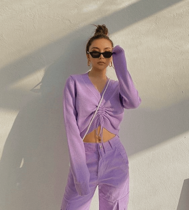 chica de cabello oscuro con crop top de manga larga morado lila, pantalón morado pastel