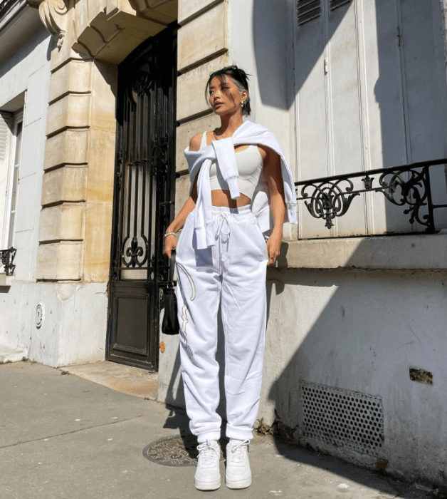 chica de cabello negro con azul, crop top blanco, sudadera blanca, pants blancos holgados, tenis blancos