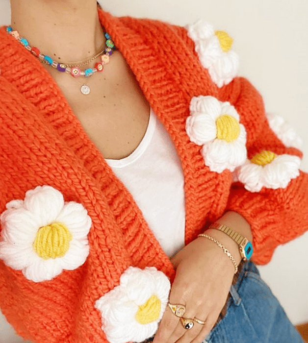 cárdigan naranja brillante con flores blancas grandes, top blanco, jeans ajustados