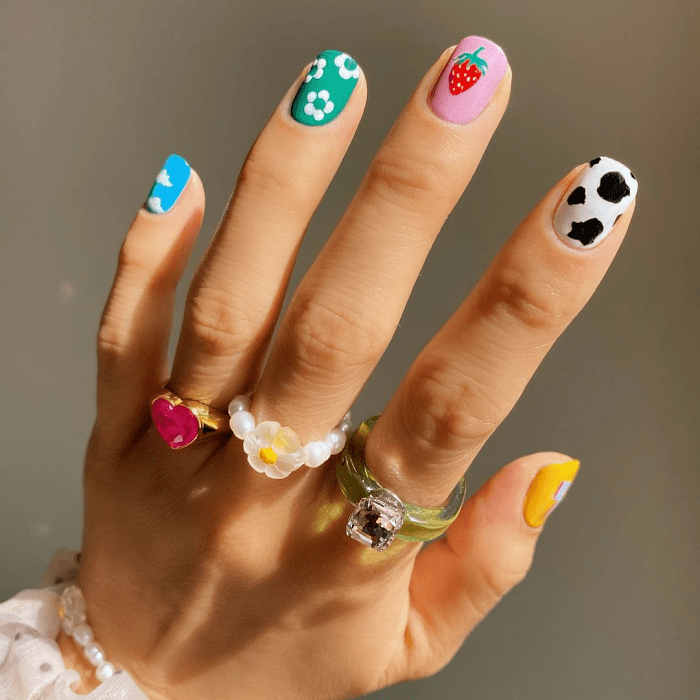 uñas con diseño colorido en tonos rosa, morado, lila, con flores, arcoíris, animal print, tonos verde, rosa, morado, azul pastel, anillos de oro