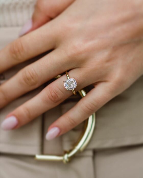 Anillo de compromiso en tono dorado con una piedra color transparente 