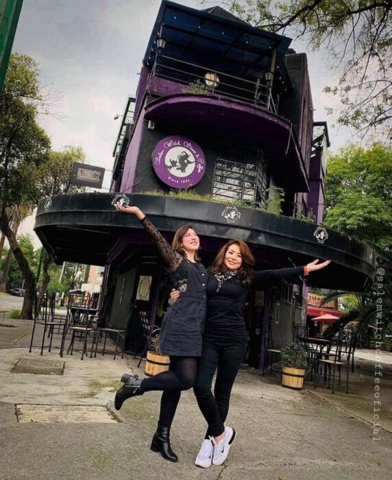 Chicas frente a la cafetería Salem Witch Stor & Coffe; ;Esta cafetería inspirada en brujas sirve las mejores posiciones del mundo oscuro