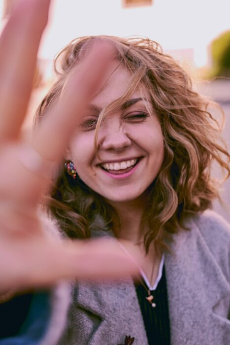 Chica sonriendo y enfocando su rostro ;Diseño de sonrisa, el procedimiento dental que las celebridades están amando