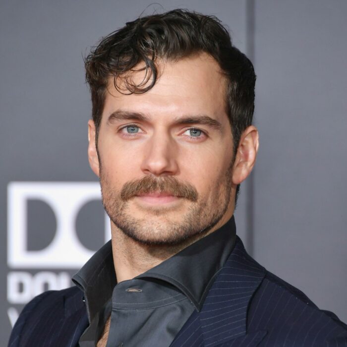 Henry Cavill posando para una fotografía en una alfombra roja 