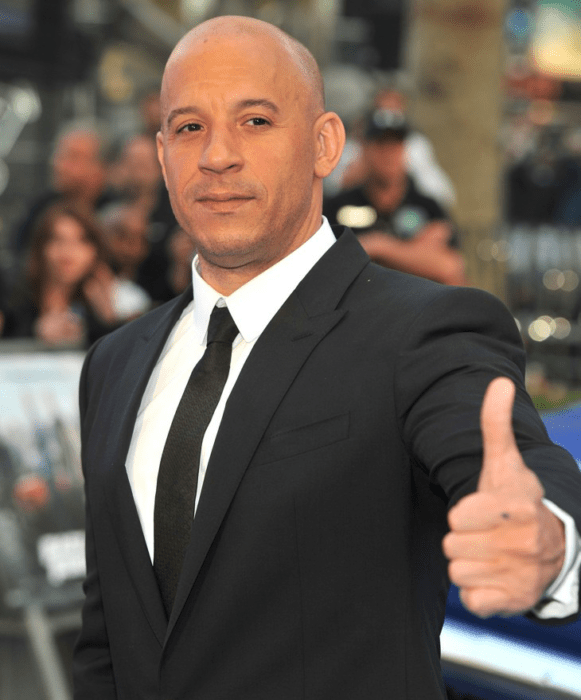 Vin Diesel posando para una foto en una alfombra roja 