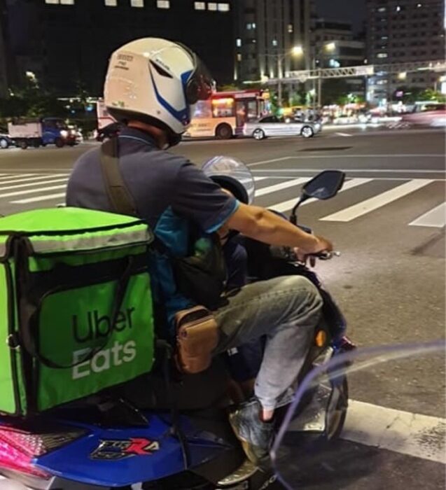 Padre e hijo repartiendo comida en una motocicleta