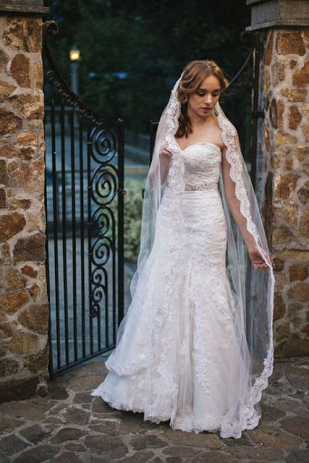 Girl wearing a matching lace dress and veil