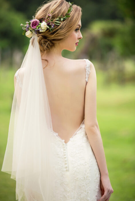 Bride wearing a low-cut dress with a plain veil 