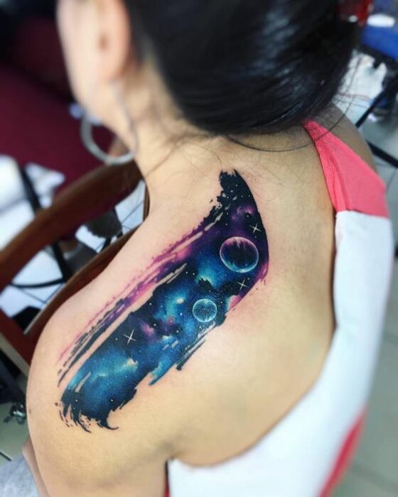 Chica con un tatuaje de planetas en diferentes colores 