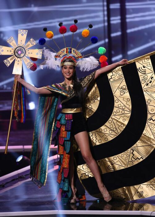 Miss universo usando su traje típico en colores dorados con negro