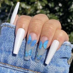 Chica con unas uñas extra largas con diseño en color blanco con mariposas