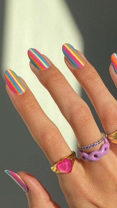 Chica con las uñas pintadas en diferentes colores 