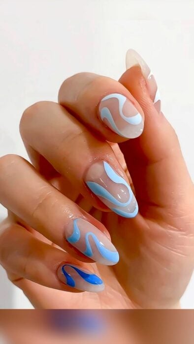 Chica con las uñas pintadas en tonos  azules 