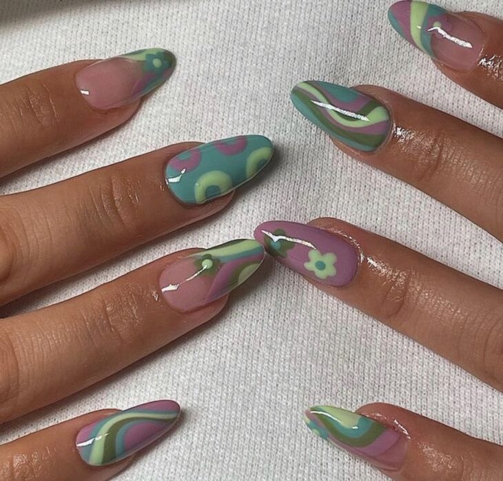 Chica con las uñas pintadas en tonos morados con verde  